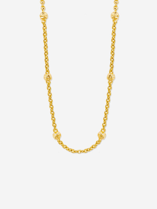 A gold choker necklace with organic gold beads dotted along the chain