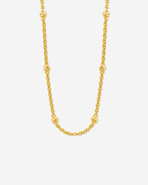 A gold choker necklace with organic gold beads dotted along the chain