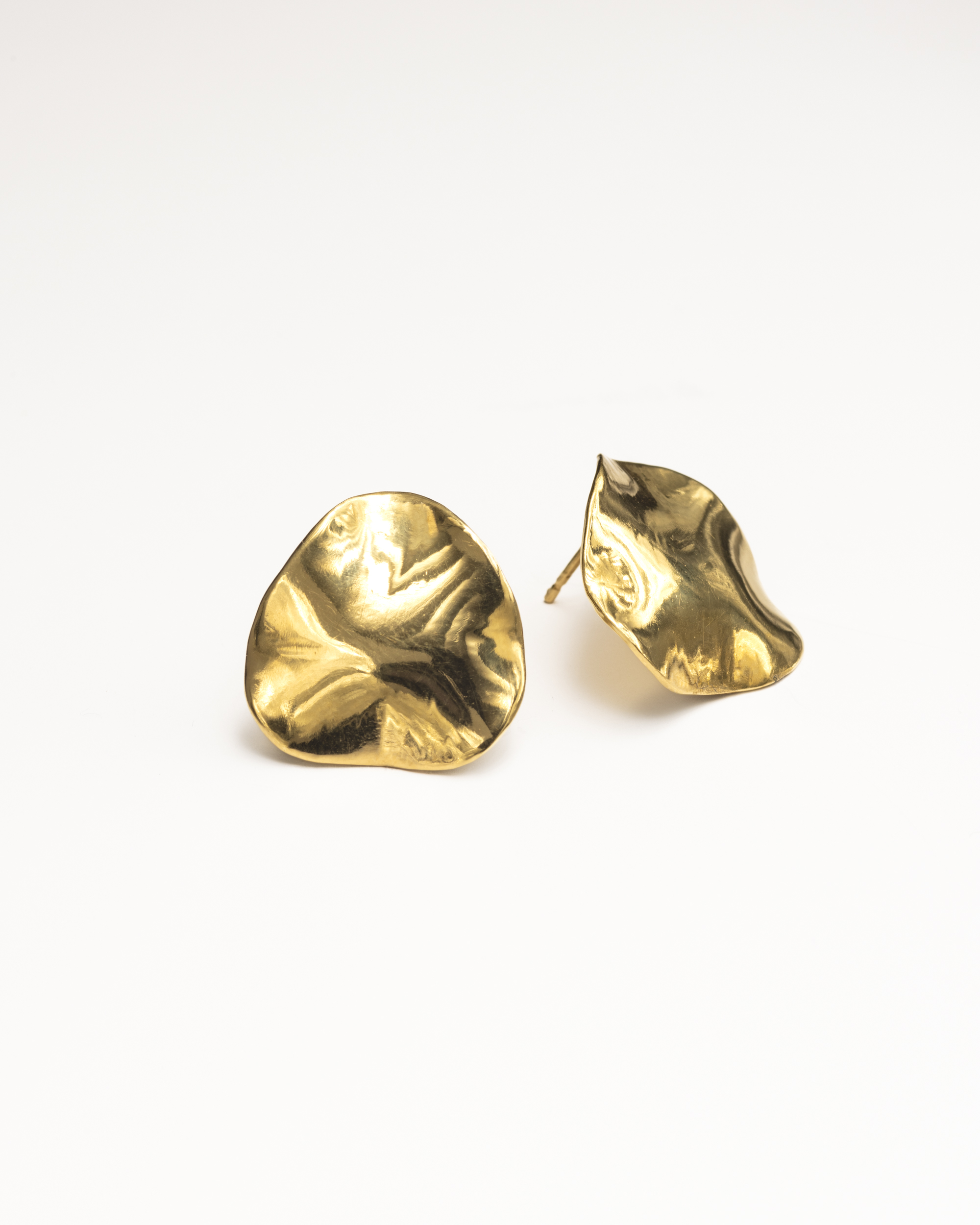 Close-up of polished gold vermeil Tide earrings showing the smooth, wavy finish