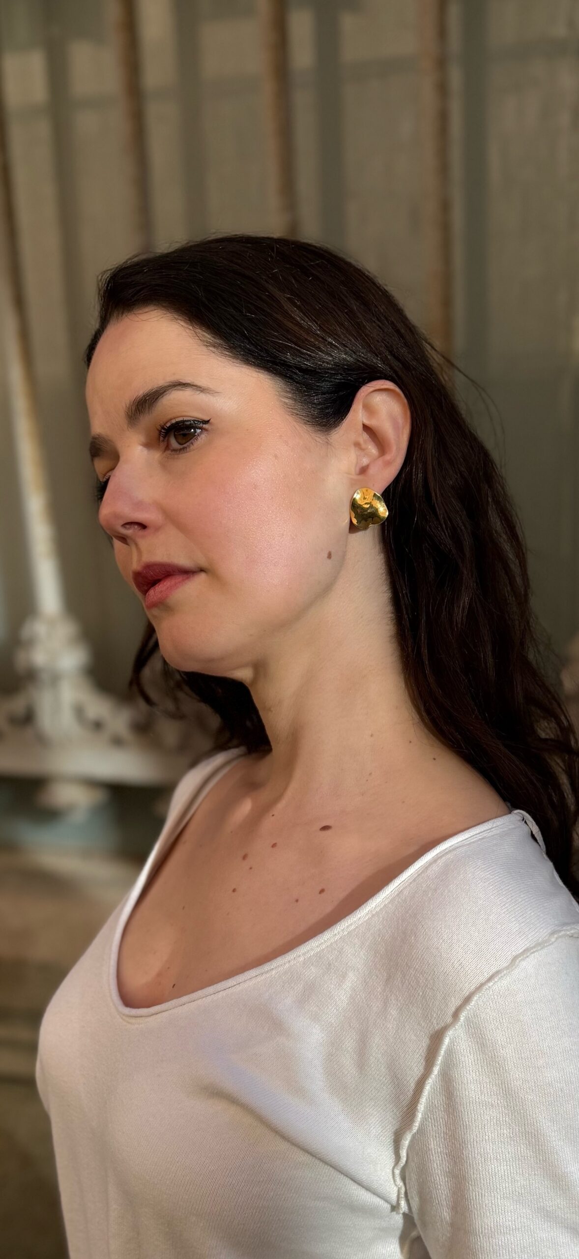 Woman wearing chunky gold vermeil Tide statement earrings